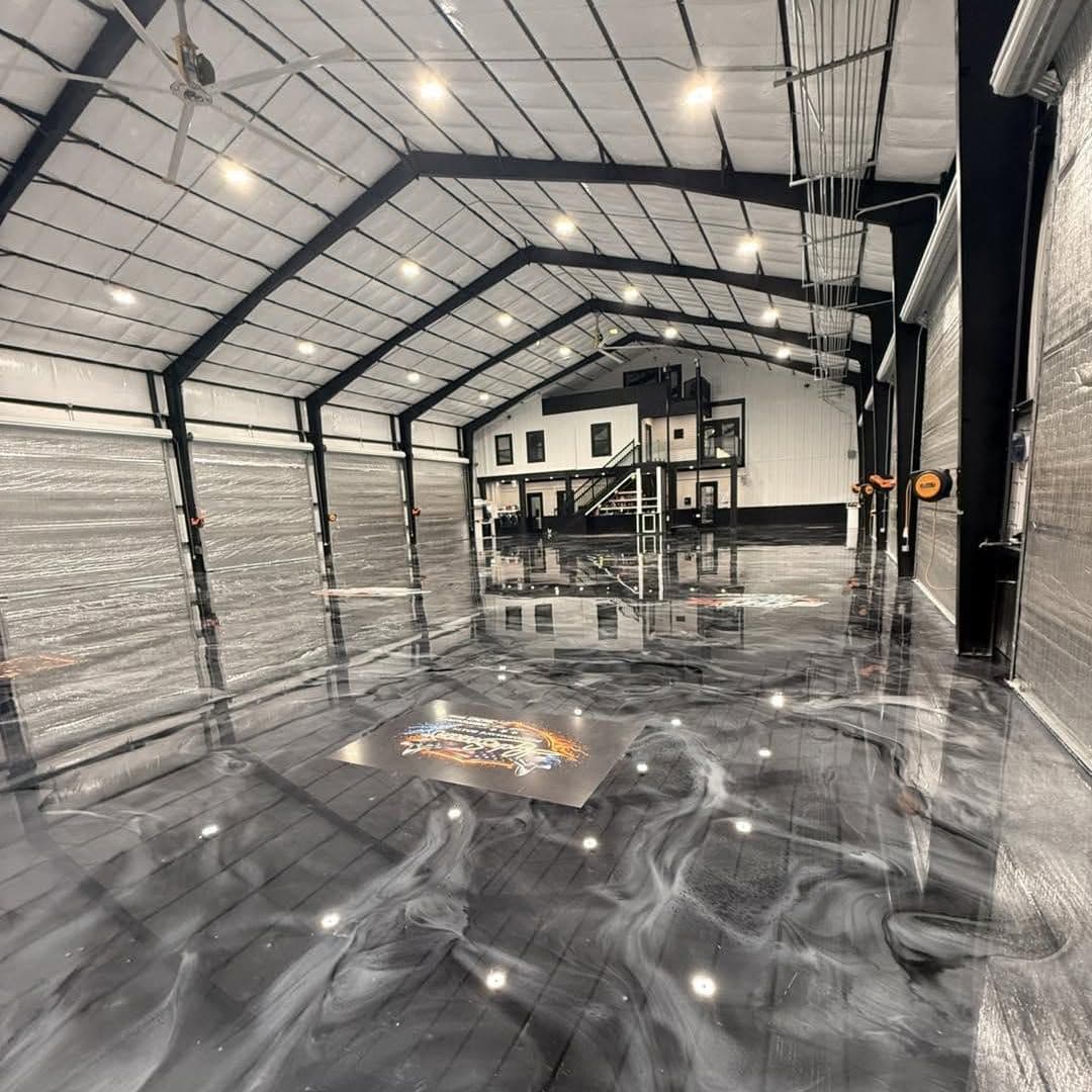 Finished steel barndominium interior with a glossy marbled epoxy floor, recessed lights and black steel frames