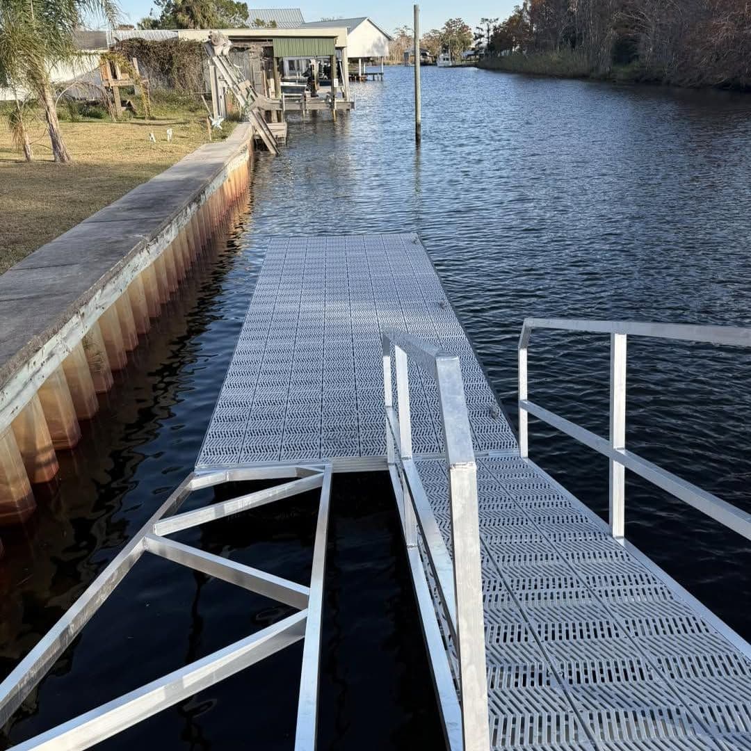 Aluminum gangway and long floating dock running along a seawall on a residential canal