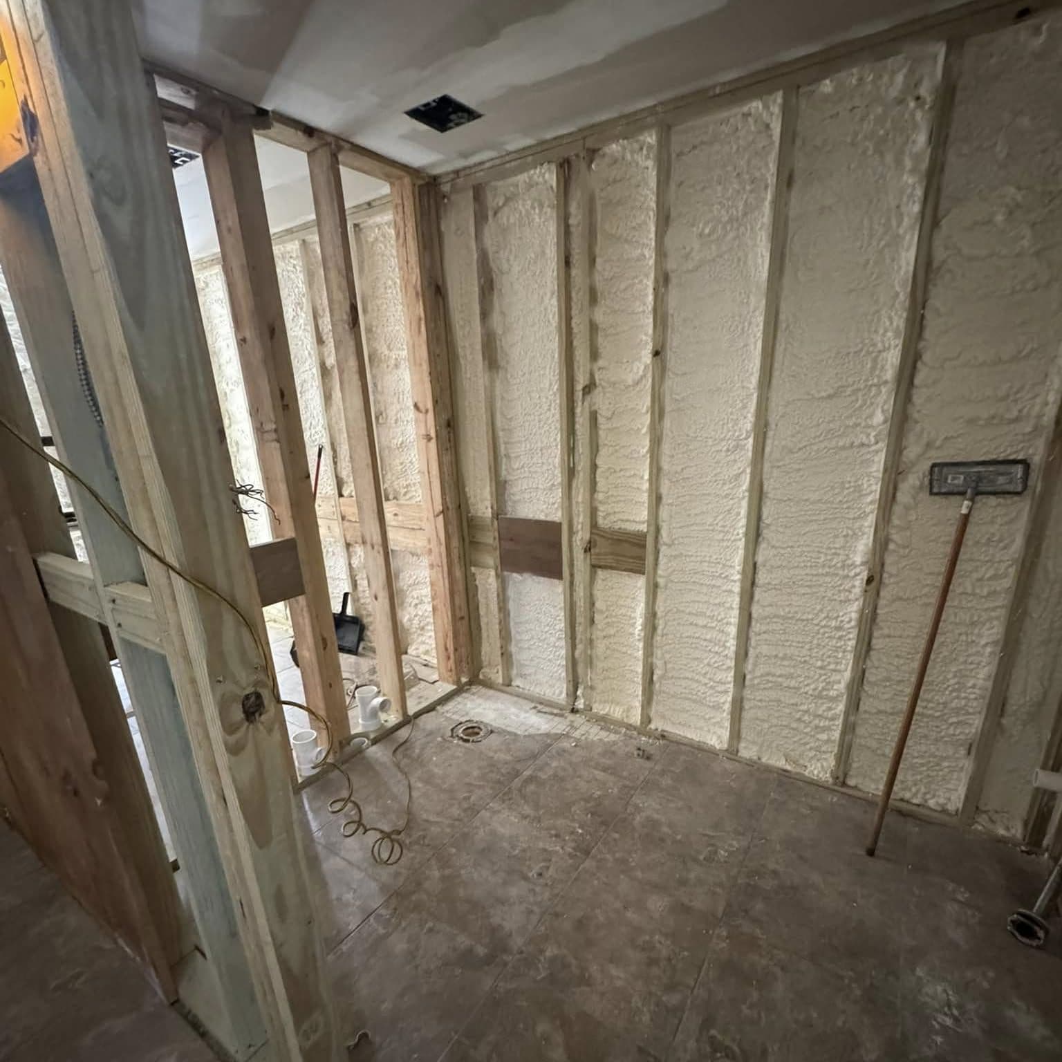 Wood-framed room with fresh spray-foam insulation between the studs