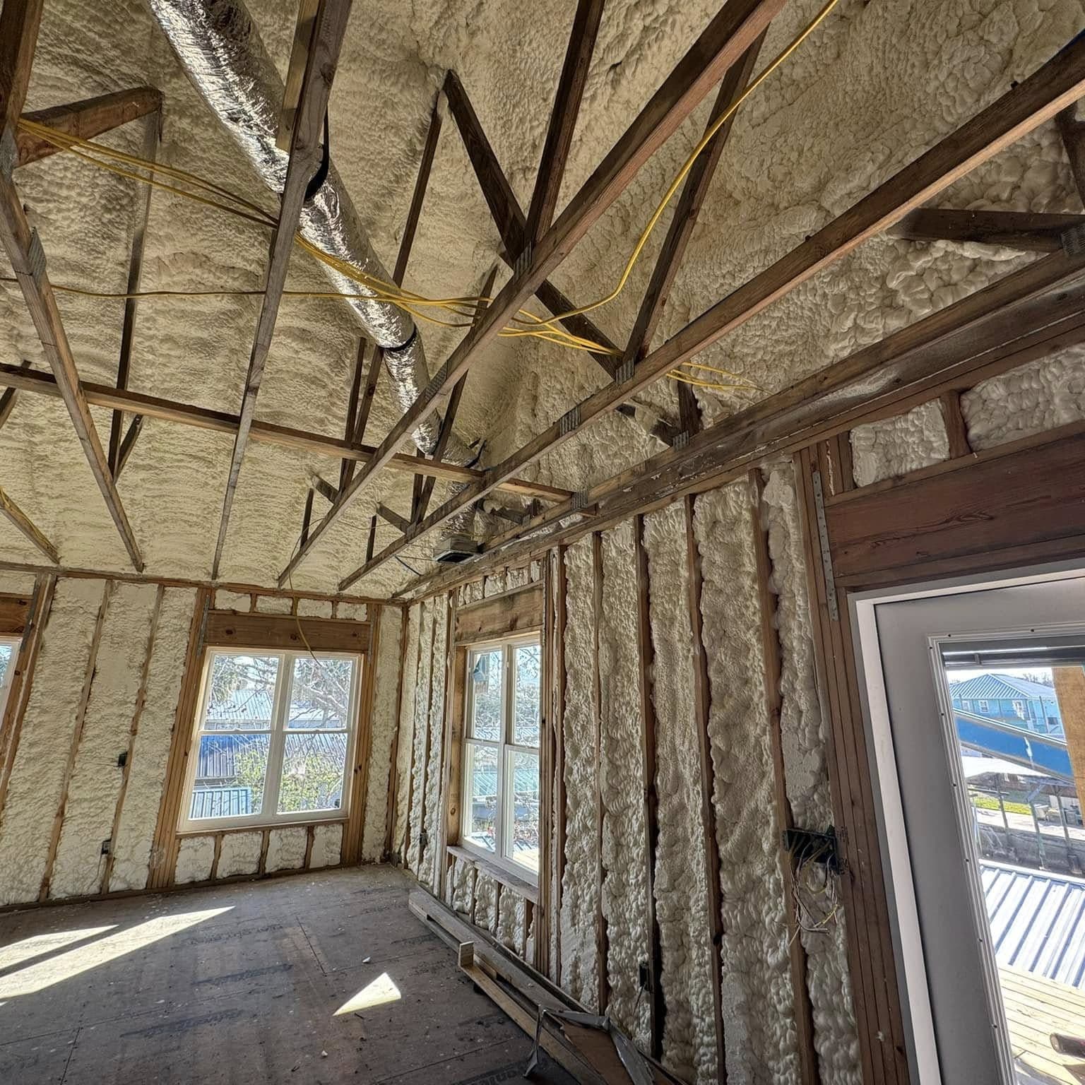 Vaulted room framing with spray-foam insulation in the walls and roof and new windows