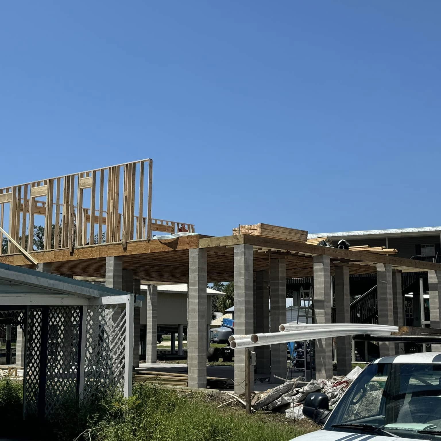 Wood wall framing going up on a raised floor deck supported by concrete-block piers