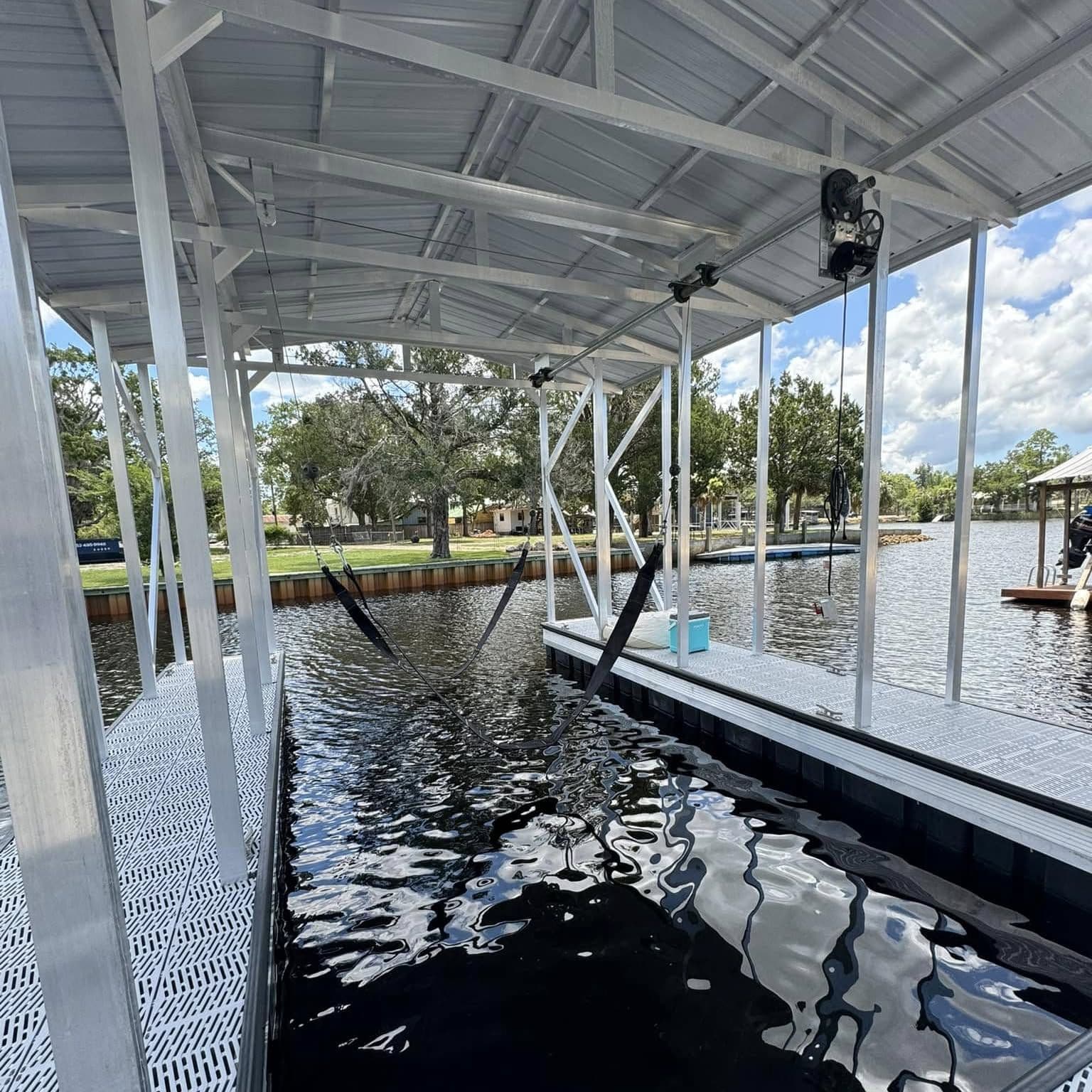 Inside a covered slip: lift motors mounted on the aluminum roof framing over open water